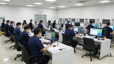 Profissionais planejando operações em um centro de distribuição moderno, com caixas, esteiras automatizadas, telas de dados e veículos de transporte ao fundo