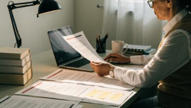 Profissional experiente revisa seu currículo em uma mesa organizada, com notebook aberto e ambiente de trabalho claro e acolhedor.