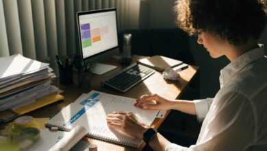 Profissional organizando prioridades e planejando uma rotina de trabalho equilibrada em uma mesa iluminada, com agenda e computador