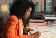 Profissional em ambiente de trabalho organizando tarefas em uma agenda, analisando prazos e destacando prioridades em um planejamento semanal.
