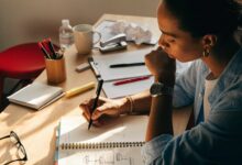 Profissional planejando metas de carreira em um caderno, com etapas e prioridades organizadas em uma mesa de trabalho iluminada.