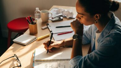 Profissional planejando metas de carreira em um caderno, com etapas e prioridades organizadas em uma mesa de trabalho iluminada.